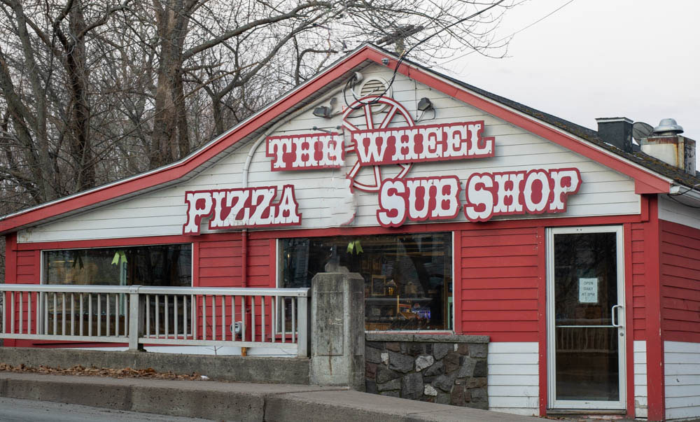 Exterior of The Wheel pizza shop in Antigonish, Nova Scotia, with its iconic signage and welcoming storefront